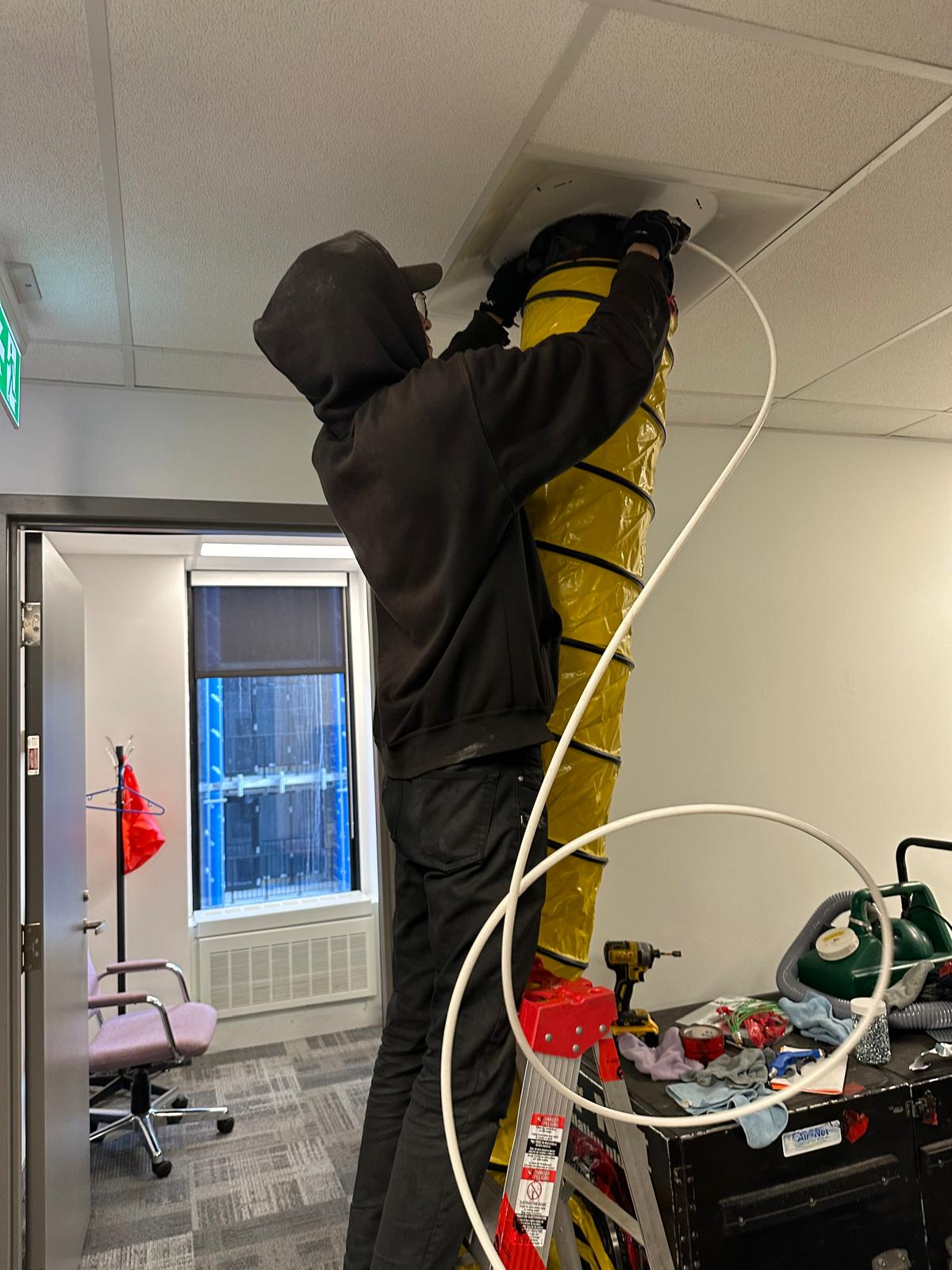 Technicien raccordant l’équipement à un conduit de ventilation