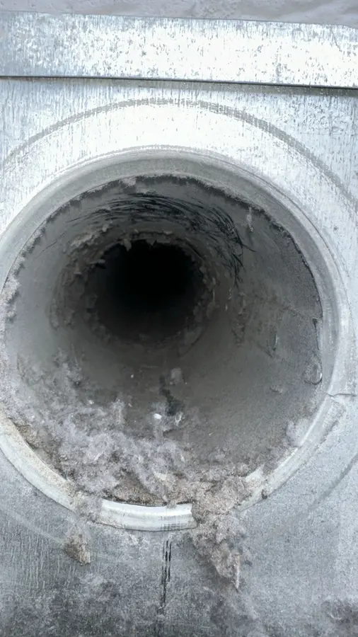 Conduit rond obstrué par de la charpie avant le nettoyage