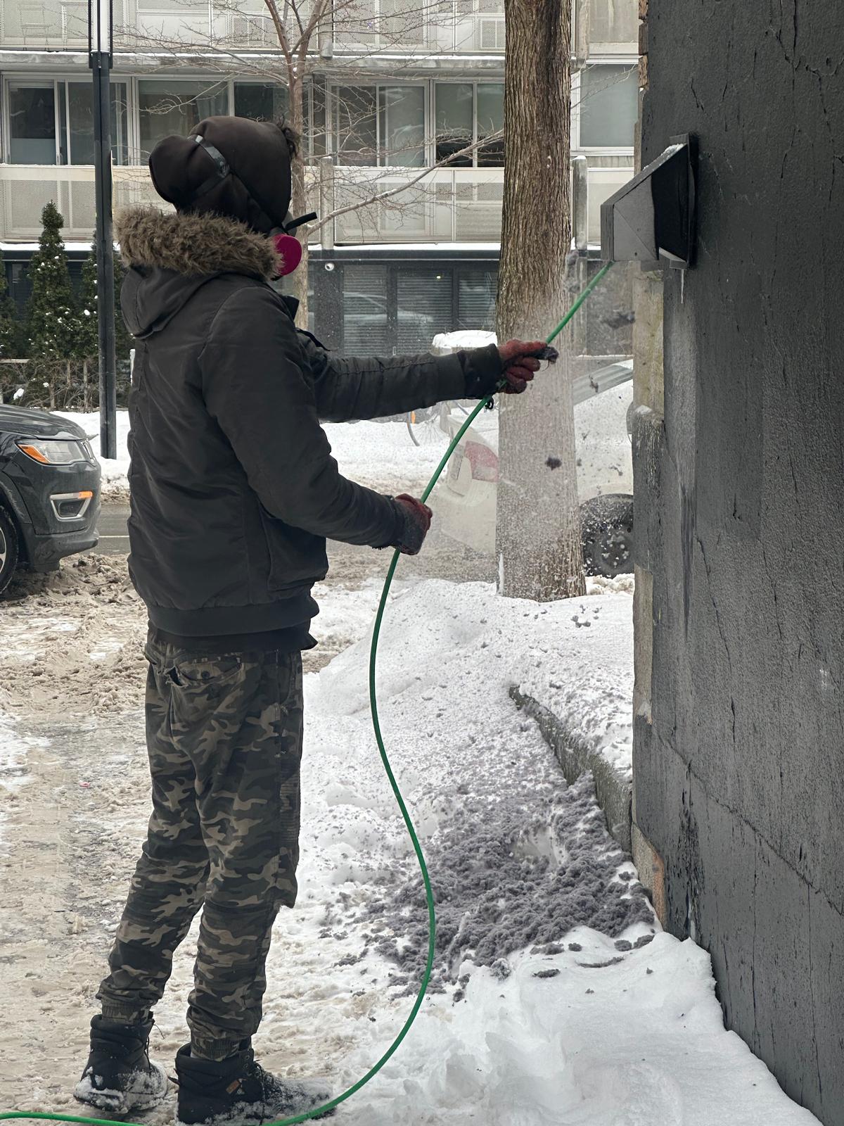 Technicien nettoyant une sortie de ventilation extérieure